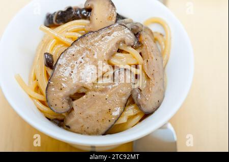 Italiano gli spaghetti e i funghi selvatici freschi sulla tavola in legno rustico Foto Stock