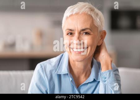 Ritratto di una donna matura allegra con i capelli corti grigi per interni Foto Stock
