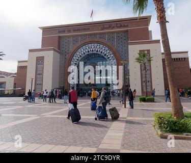 Viaggiatori fuori dalla moderna stazione ferroviaria con facciata in vetro nella città di Marrakech, alias Marrakech, Marocco, 11 dicembre 2023 Foto Stock