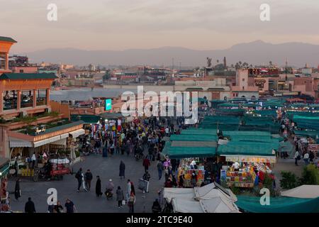 Vista su Piazza Jemaa el-Fna in serata al tramonto con le montagne alle spalle. Marrakech, alias Marrakech, Marocco, 11 dicembre 2023 Foto Stock