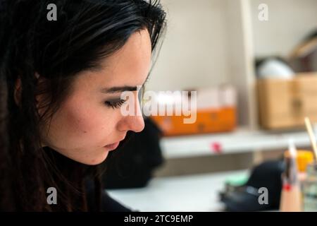 Rotterdam, Paesi Bassi. Attraente bruna donna di profilo, che lavora al via Kunst Art Studio Foto Stock