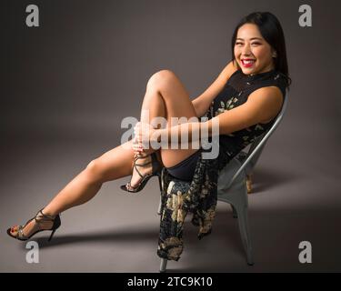 Bella giovane donna asiatica Curvy Fit Athletic stampa floreale cheongsam Foto Stock