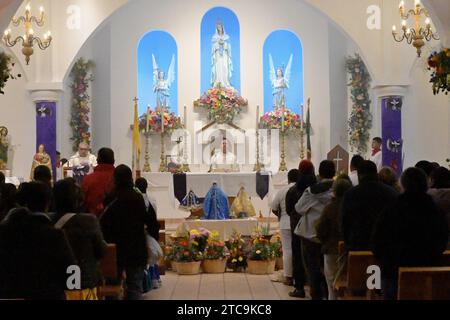 Tijuana, Baja California, Messico. 9 dicembre 2023. La comunità di Oaxacan di Tijuana, Messico, ha celebrato il 10 dicembre 2023 la tradizionale processione Mixteca di "calenda" per la Virgen di Juquila, il suo decimo anno osservato da alcuni residenti che vivono nell'area del Camino Verde. I sacerdoti benedicono le figure della vergine per una cerimonia e una messa nella chiesa parrocchiale di Nuestra SeÃ±ora de la EncarnaciÃ³n. (Immagine di credito: © Carlos A. Moreno/ZUMA Press Wire) SOLO USO EDITORIALE! Non per USO commerciale! Foto Stock