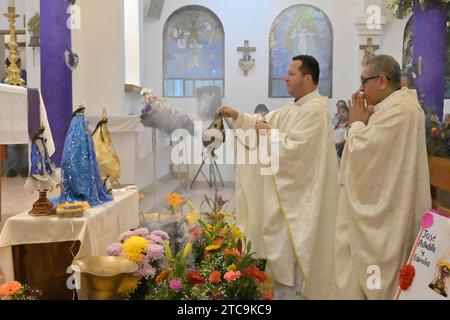 Tijuana, Baja California, Messico. 9 dicembre 2023. La comunità di Oaxacan di Tijuana, Messico, ha celebrato il 10 dicembre 2023 la tradizionale processione Mixteca di "calenda" per la Virgen di Juquila, il suo decimo anno osservato da alcuni residenti che vivono nell'area del Camino Verde. I sacerdoti benedicono le figure della vergine per una cerimonia e una messa nella chiesa parrocchiale di Nuestra SeÃ±ora de la EncarnaciÃ³n. (Immagine di credito: © Carlos A. Moreno/ZUMA Press Wire) SOLO USO EDITORIALE! Non per USO commerciale! Foto Stock