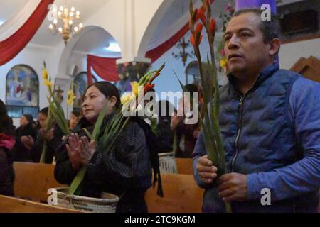 Tijuana, Baja California, Messico. 9 dicembre 2023. La comunità di Oaxacan di Tijuana, Messico, ha celebrato il 10 dicembre 2023 la tradizionale processione Mixteca di "calenda" per la Virgen di Juquila, il suo decimo anno osservato da alcuni residenti che vivono nell'area del Camino Verde. Il festival includeva i partecipanti in abiti tradizionali diretti alla loro destinazione finale per una cerimonia e una messa presso la chiesa parrocchiale di Nuestra SeÃ±ora de la EncarnaciÃ³n. (Immagine di credito: © Carlos A. Moreno/ZUMA Press Wire) SOLO USO EDITORIALE! Non per USO commerciale! Foto Stock