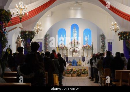 Tijuana, Baja California, Messico. 9 dicembre 2023. La comunità di Oaxacan di Tijuana, Messico, ha celebrato il 10 dicembre 2023 la tradizionale processione Mixteca di "calenda" per la Virgen di Juquila, il suo decimo anno osservato da alcuni residenti che vivono nell'area del Camino Verde. I sacerdoti benedicono le figure della vergine per una cerimonia e una messa nella chiesa parrocchiale di Nuestra SeÃ±ora de la EncarnaciÃ³n. (Immagine di credito: © Carlos A. Moreno/ZUMA Press Wire) SOLO USO EDITORIALE! Non per USO commerciale! Foto Stock