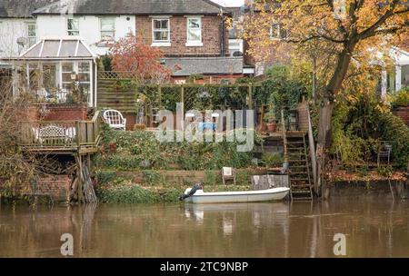 Shrewsbury, Shropshire, Regno Unito - 22 novembre 2022 - guardando oltre il fiume le case i cui giardini tornano sull'acqua e hanno gradino Foto Stock