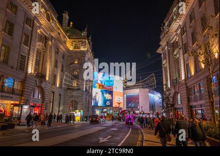 Londra, Regno Unito. 11 dicembre 2023.. Una serata vivace e asciutta nel centro di Londra con migliaia di visitatori che guardano le impressionanti decorazioni natalizie in Regent Street con il display pubblicitario Piccadilly Circus in lontananza. Crediti: Malcolm Park/Alamy Live News Foto Stock