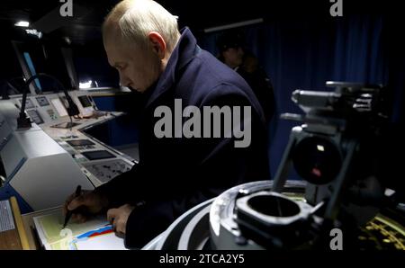 Severodvinsk, Russia. 11 dicembre 2023. Il presidente russo Vladimir Putin firma il libro degli ospiti durante un tour del ponte a bordo della fregata classe Admiral Gorshkov ammiraglio Kasatonov presso i cantieri navali di Sevmash, 12 dicembre 2023 a Severodvinsk, regione di Arcangelo, Russia. Crediti: Mikhael Klimentyev/Cremlino Pool/Alamy Live News Foto Stock