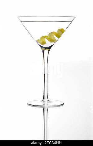 Martini bevanda miscelata con olio di oliva guarnite su uno sfondo grigio chiaro con la riflessione Foto Stock