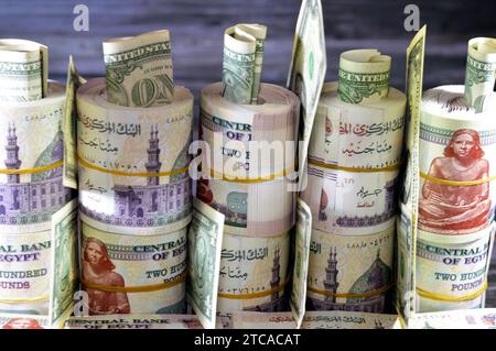 Pile e pacchi di denaro egiziano migliaia di sterline banconote banconote in valuta rotoli di 200 EGP LE, tasso di cambio egiziano e bambola americana USA Foto Stock