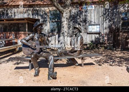 Luckenbach, USA - 2 novembre 2023: Jerry Jeff Walkers Hondo Crouch Statua di un cowboy che suona la chitarra svelata a Luckenbach , Texas. Foto Stock