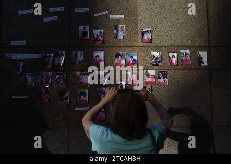 Santiago, metropolitana, Cile. 11 dicembre 2023. Una donna fotografa un murale con immagini di bambini palestinesi uccisi in guerra, durante una manifestazione di fronte all'ambasciata degli Stati Uniti a Santiago per chiedere un cessate il fuoco nella Striscia di Gaza. (Immagine di credito: © Matias Basualdo/ZUMA Press Wire) SOLO USO EDITORIALE! Non per USO commerciale! Foto Stock