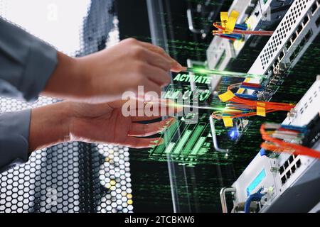 Nella sala server, un tecnico sta gestendo le apparecchiature utilizzando un dispositivo AR. Foto Stock
