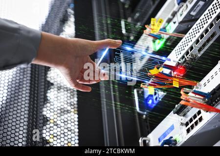 Nella sala server, un tecnico sta gestendo le apparecchiature utilizzando un dispositivo AR. Foto Stock
