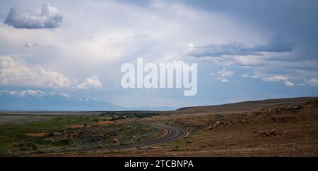 Un'autostrada aperta negli Stati Uniti, circondata da un vasto paesaggio con sopra un cielo nuvoloso Foto Stock