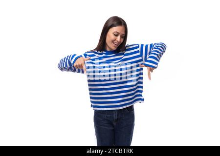 la bella bruna sottile con capelli lisci è vestita con abiti da marinaio a righe blu Foto Stock