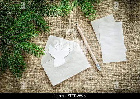 Branco dell'albero di Natale lettera angelo matita su sfondo burlap Foto Stock