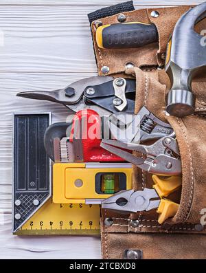 Cintura portautensili in pelle attrezzi di costruzione su pannello in legno concetto di costruzione Foto Stock