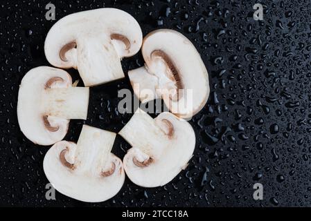 Molti campaignoni freschi di funghi sliliced isolati su sfondo nero, vista dall'alto. Un sano background alimentare. Spazio di copia Foto Stock