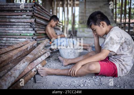 Concetto di lavoro minorile, bambini poveri vittime del lavoro edile, tratta di esseri umani, abusi sui minori. Foto Stock