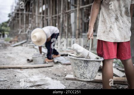 Concetto di lavoro minorile, bambini poveri vittime del lavoro edile, tratta di esseri umani, abusi sui minori. Foto Stock