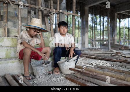 Concetto di lavoro minorile, bambini poveri vittime del lavoro edile, tratta di esseri umani, abusi sui minori. Foto Stock