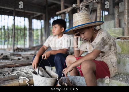 Concetto di lavoro minorile, bambini poveri vittime del lavoro edile, tratta di esseri umani, abusi sui minori. Foto Stock