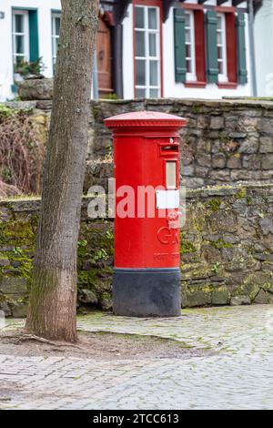 Cassetta postale in inglese rosso di fronte a un muro di pietra a Bad Muenstereifel, Germania Foto Stock