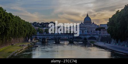 Una foto del sole che tramonta sulla St. Angelo Bridge e il St. La Basilica di Pietro Foto Stock