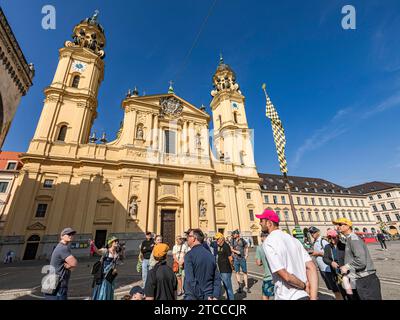 I turisti in un tour della città di fronte alla chiesa dei teatri di Odeonsplatz, Monaco, Baviera, Germania, aperto Foto Stock