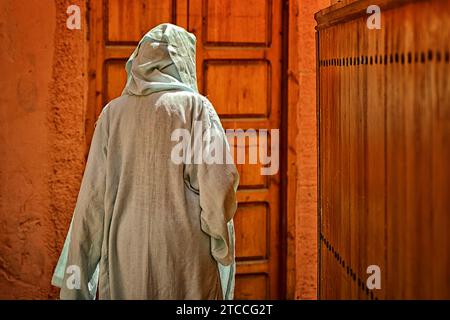 Una donna marocchina che indossa il niqab cammina all'interno di un vicolo della Medina di Marrakech o di Marrakech. Abito femminile islamico tradizionale. Foto Stock