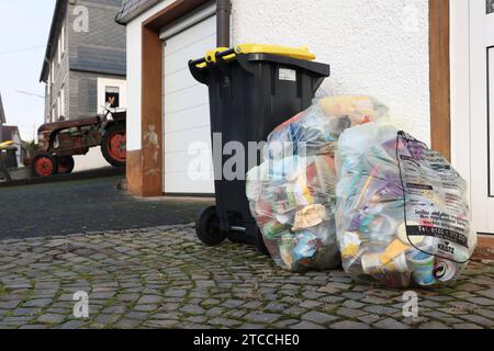 Muell Müll, Gelbe Saecke Säcke und eine Gelbe tonne, Pre Zero draussen. Es gibt immer wieder Aerger Ärger da die firma Pre Zero es nicht schafft die gelbe tonne abzufahren. Inzwischen steht der Muell Müll seit zwei Wochen vor den Haeusern Häusern Muell Müll, Muellabfuhr Müllabfuhr im Siegerland AM 12.12.2023 a Siegen/Deutschland. *** Spazzatura, sacchetti gialli e una spazzatura gialla, Pre Zero fuori c'è sempre problema perché l'azienda Pre Zero non riesce a rimuovere la spazzatura gialla nel frattempo, la spazzatura è stata in piedi di fronte alle case per due settimane spazzatura, Garb Foto Stock