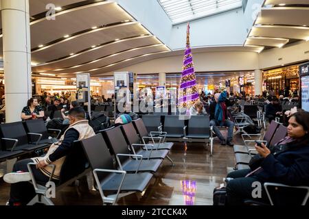 Londra, Regno Unito. 12 dicembre 2023. Passeggeri al Terminal 3 dell'aeroporto di Heathrow prima delle festività natalizie. È stato riferito che l’Arabia Saudita potrebbe assumere il controllo della maggioranza effettiva di Londra Heathrow, il principale aeroporto del Regno Unito, con altri investitori che stanno valutando la possibilità di vendere le loro partecipazioni. Il Fondo pubblico di investimento (PIF) dello stato ricco di petrolio insieme all’investitore di private equity Ardian per annunciare l’acquisto di una partecipazione del 25% nell’aeroporto il mese scorso da Ferrovial, l’impresa spagnola di infrastrutture che era stata il proprietario primario di Heathrow per 17 anni. Crediti: Stephen Chung / Alamy Live News Foto Stock