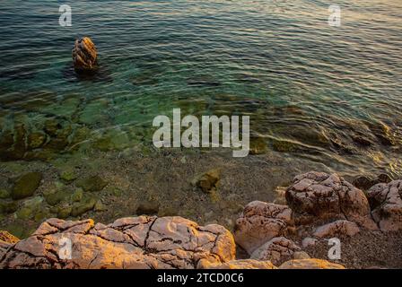 Tarda estate sulla costa rocciosa di Novi Vinodolski, Primorje-Gorski Kotar County, Croazia. Metà settembre. Nel tardo pomeriggio il sole è basso. Foto Stock