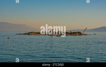 Crepuscolo sull'isola di San Marino al largo della costa adriatica di Novi Vinodolski, Primorje-Gorski Kotar, Croazia. Metà settembre. Cappella SV Martina sull'isola Foto Stock