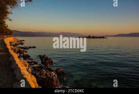 Crepuscolo sull'isola di San Marino al largo della costa adriatica di Novi Vinodolski, Primorje-Gorski Kotar, Croazia. Metà settembre. Cappella SV Martina sull'isola Foto Stock