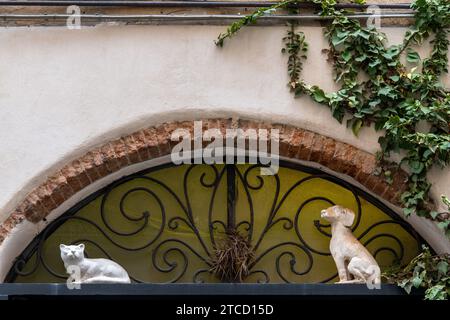 Una lunetta sulla porta decorata con statuette di gatto e cane nel borgo medievale di Finalborgo, finale Ligure, Savona, Liguria, Italia Foto Stock