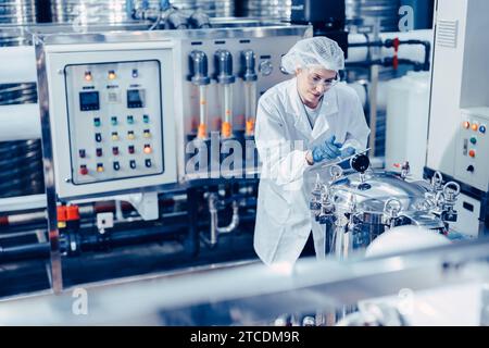 personale addetto all'igiene in fabbrica pulita di cibi e bevande. donne che lavorano nel controllo qualità dell'industria degli impianti idrici. Foto Stock