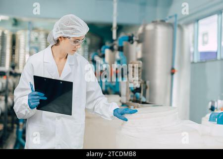 gli scienziati lavorano negli impianti di trattamento delle acque controllando la qualità e la pulizia della purezza dell'acqua nel serbatoio del contenitore. Foto Stock