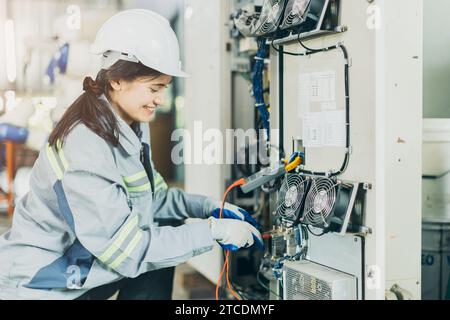 Elettricisti lavoratrici che controllano riparazione manutenzione riparazione riparazione assistenza impianto elettrico. ingegnere elettricista di sesso femminile, prova il cavo elettrico alla presa principale Foto Stock