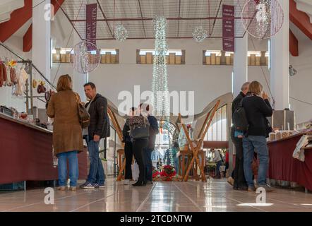 Felanitx, Spagna; 10 dicembre 2023: Decorazioni natalizie all'interno del mercato comunale nella città di Felanitx, Spagna, con i clienti che fanno shopping Foto Stock