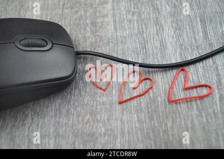 mouse per computer con graffette rosse a forma di cuore, amore in ufficio Foto Stock