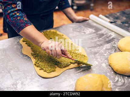 Processo di cottura della torta di Natale, pane dolce ricoperto di crema al pistacchio Foto Stock