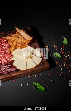 gustoso tagliere di salumi con selezione di formaggi gourmet, carne secca e salame nero Foto Stock