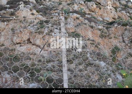 Recinzione delle maglie della catena rinforzata con anelli in acciaio per proteggersi dalla caduta di rocce Foto Stock