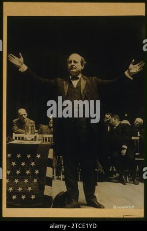 William Jennings Bryan e a piena lunghezza vista con le braccia distese, in piedi accanto alla bandiera drapped tabella sul palco; uomini seduti in background durante il 1908 Convenzione Nazionale Democratica Foto Stock