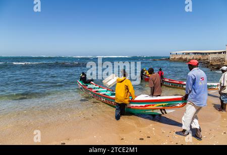 Dakar, Senegal. 18 agosto 2019: Pescatori con una barca da pesca in una spiaggia a Dakar, una delle molte spiagge di pesca di Dakar, Senegal, Africa occidentale Foto Stock