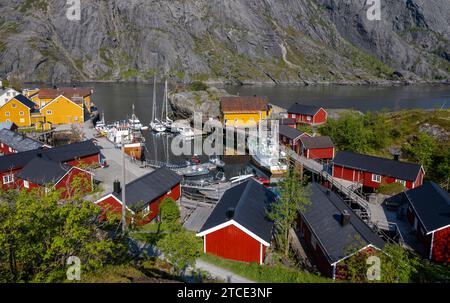 Guardando il porto a Nusfjord, Lofoten, Norvegia, con capanne rosse e gialle Foto Stock