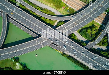 Vista aerea con droni della strada di intersezione su più livelli dell'autostrada con le auto in movimento. Cina. Foto Stock